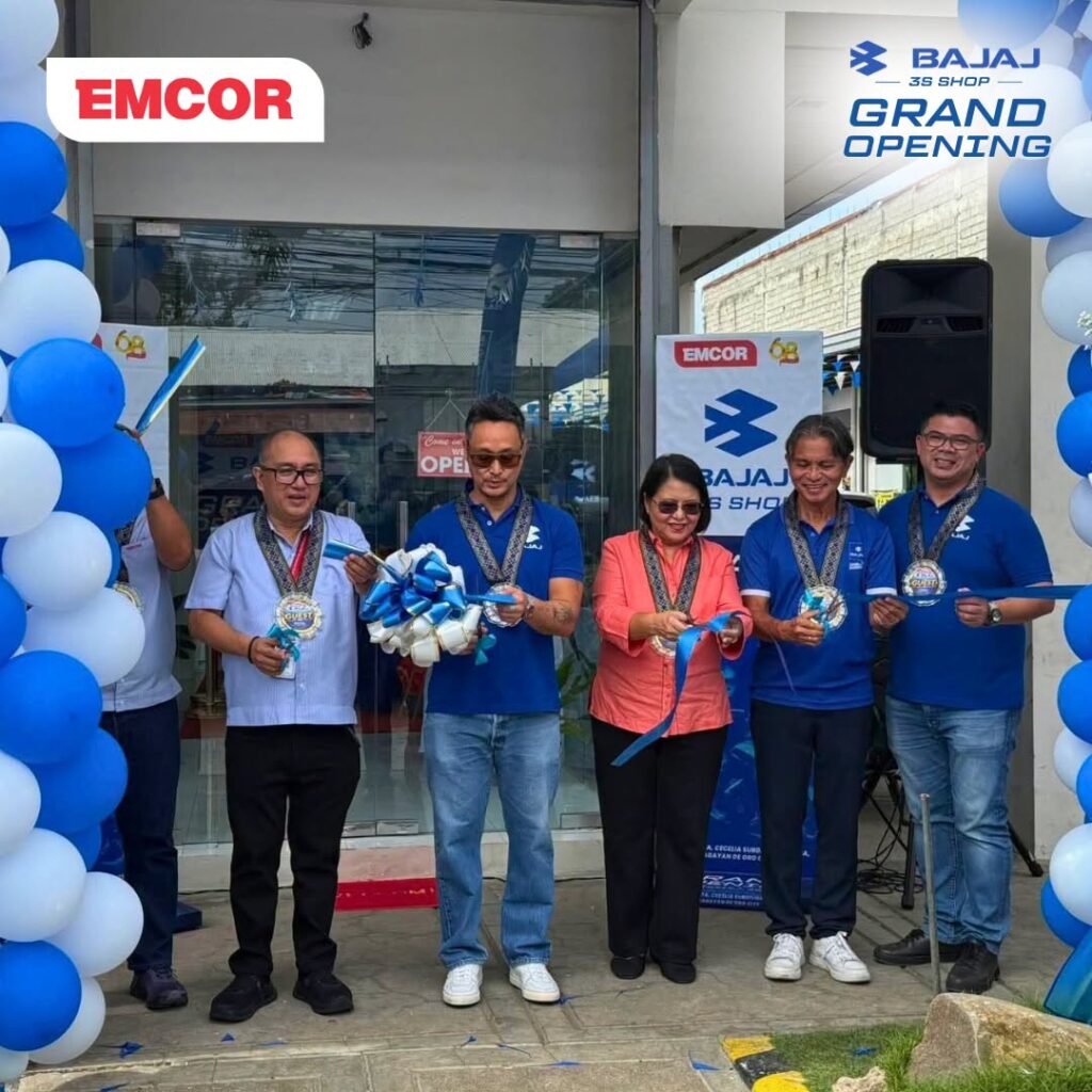 Guests wearing medals cut a blue and white ribbon at the entrance of the Bajaj 3S Shop
