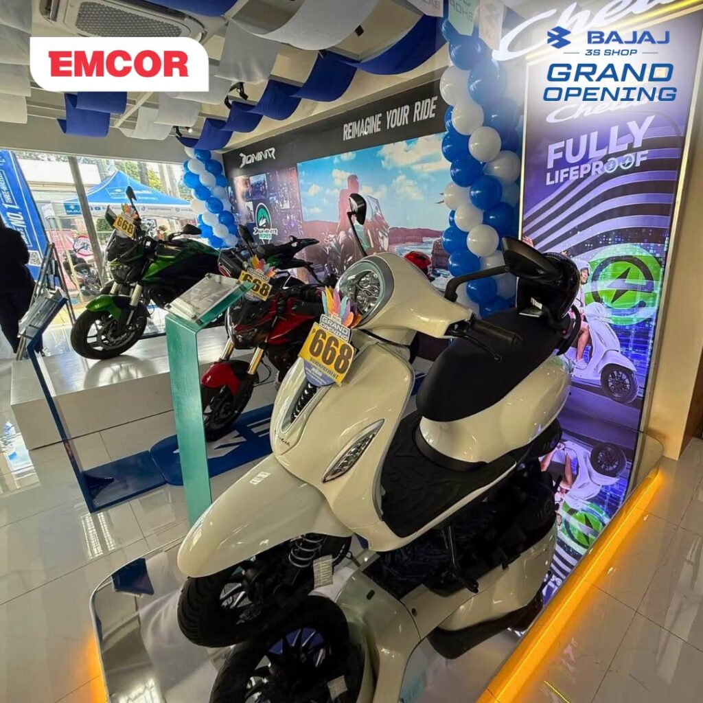 White Bajaj Chetak e-motorcycle on a lit display platform in the showroom