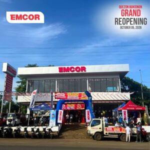 Two-storey EMCOR Quezon, Bukidnon store with grand reopening banners, an inflatable arch, motorcycles, and display tents out front