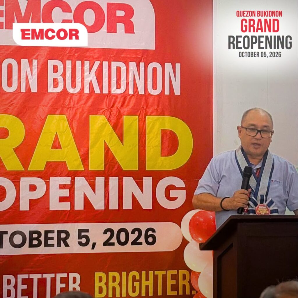 Speaker at a podium in front of a red Quezon Bukidnon Grand Reopening backdrop