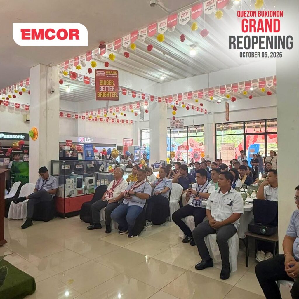 Guests seated inside a festively decorated EMCOR showroom with appliance and gadget displays in the background